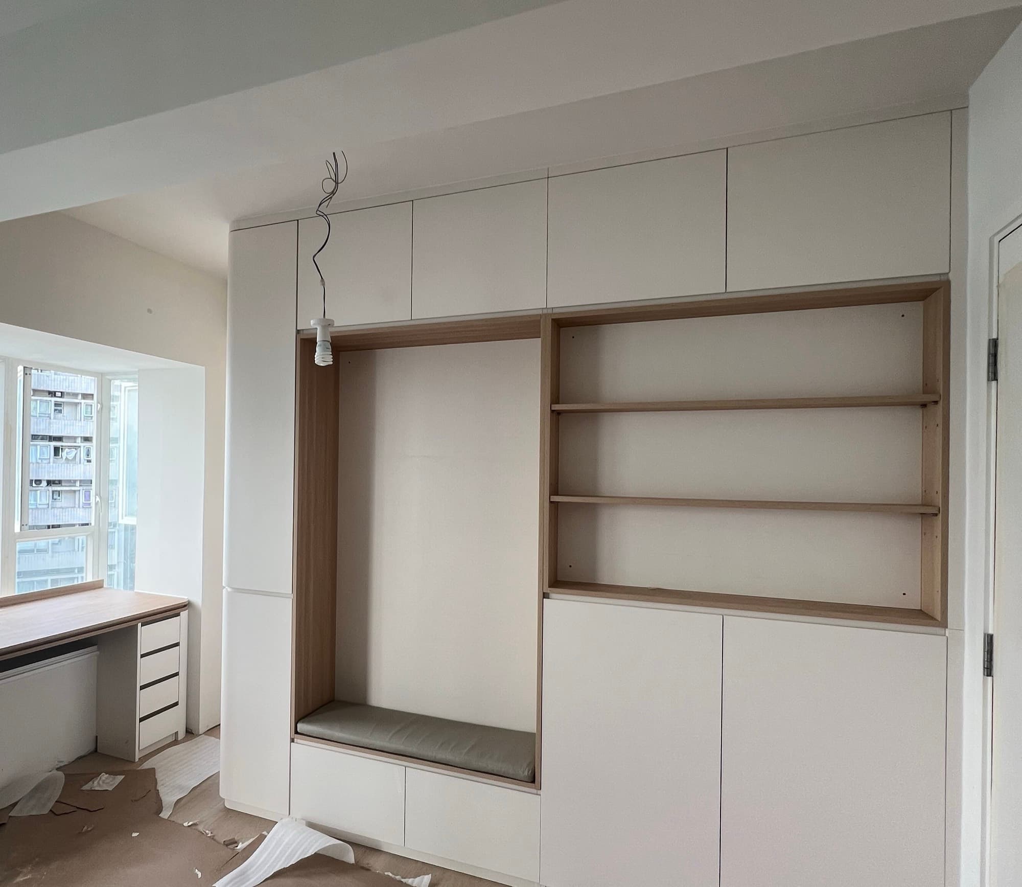 The joinery wall as built, with the oak-lined niche, cushioned bench and window desk installed