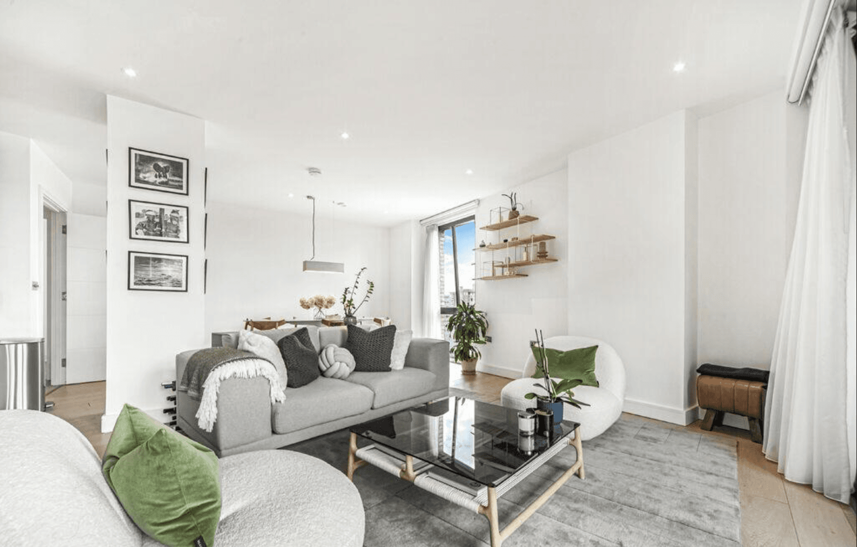 Open plan living room with a gray sofa and boucle chairs